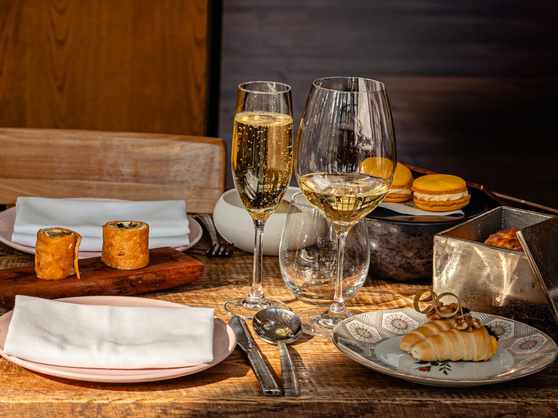 Bovenaanzicht van de Royal Tea tafel met hapjes, gebak en champagne bij Kasteel Kerckebosch